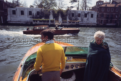 Peggy Guggenheim a bordo di un motoscafo; sullo sfondo la facciata sul Canal Grande di Palazzo Venier dei Leoni. Venezia, 1975