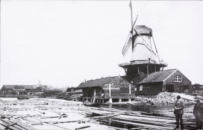 Draaiende molen met op de voorgrond de boomstammen in het water.ZUID-HOLLAND-DELFT-GOR_03940I.0000004.1