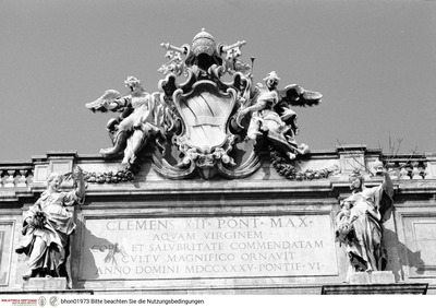 Fontana di Trevi, Zwei Personifikationen der Fama flankieren das Wappen von Papst Clemens XII.