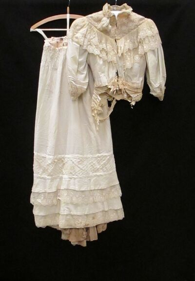 Japon, tweedelig, van witte wol, hoog gesloten, gegarneerd met crèmekleurig machinale kant en gaas, bestaande uit lijfje en rok