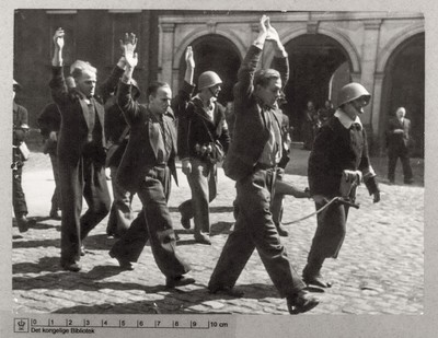 Tre anholdte under eskorte af bevæbnede frihedskæmpere, 7. maj 1945
