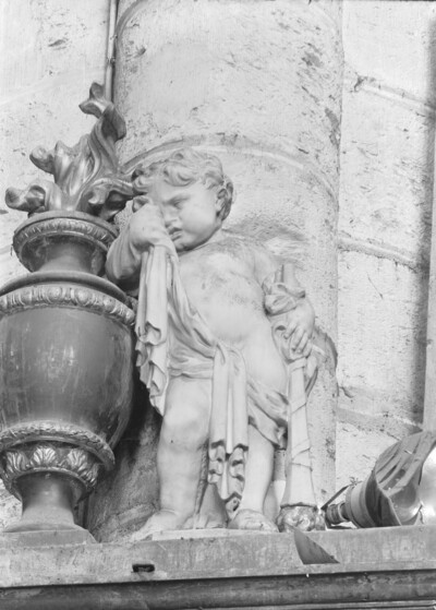 Mourning Putto on the left pillar