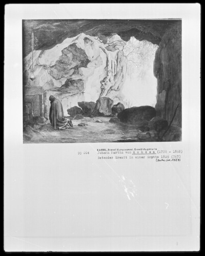 Praying hermit in a grotto