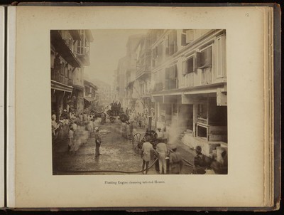 Groups of men on a street spraying jets of water into plague infected houses, during the epidemic of plague in Bombay.
