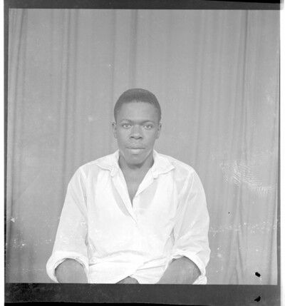 Full frontal view of a man sitting in the studio wearing a shirt.From Endangered Archives Programme EAP449, "Social history and cultural heritage of Mali"