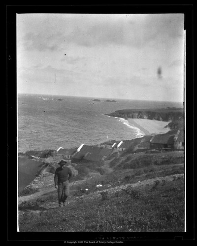Photograph of Pádraig Ó Catháin walking up a hillside behind the village above the Trá Bán, the Great Blasket Island