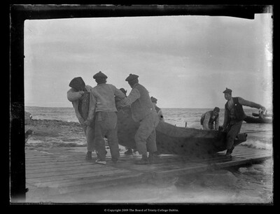 Photograph of men bringing ashore their currach at Inis Meáin