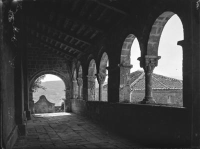 Sepúlveda. Claustro v. San Salvador [Claustro románico de la iglesia de San  Salvador con columnas de capiteles decorados con motivos vegetales. Vista  de las casas y la montaña a través del arco